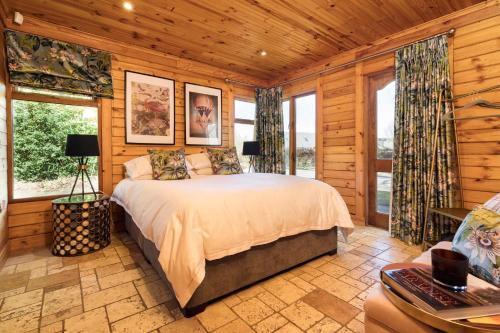 um quarto com uma cama num quarto com paredes de madeira em Castledillon Forest Lodge em Armagh