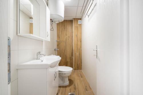 a white bathroom with a sink and a toilet at Villa Aria in Ohrid