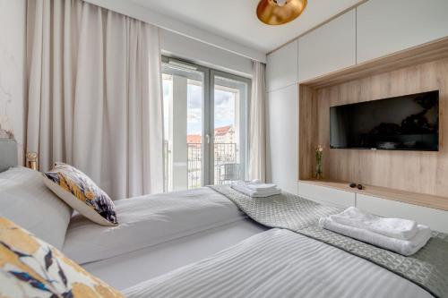 a bedroom with a large bed with a large window at Live & Travel Apartments Grano Residence in Gdańsk