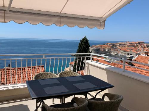 a table on a balcony with a view of the ocean at Villa Leoni in Dubrovnik