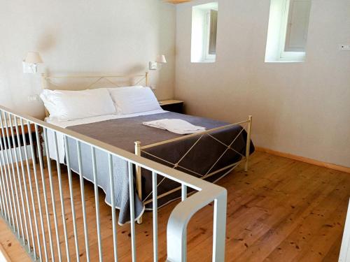 a bedroom with a bed with a railing and two windows at Relais Real Collegio in Noli