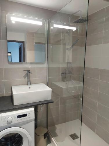 une salle de bain avec un lavabo et une machine à laver dans l'établissement Magnifique et Moderne T2 avec vue imprenable sur les Albères Turquoise 134, à Canet