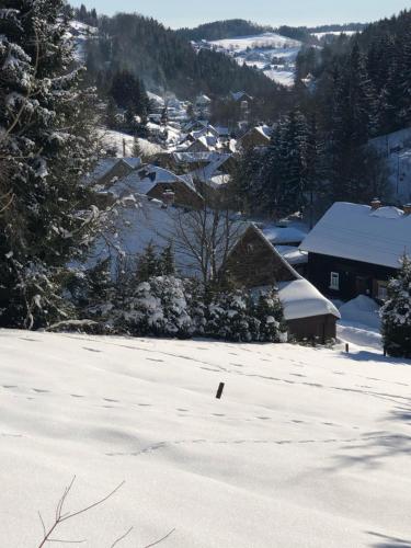 a snow covered field with a town in the background at Historisches Aschberg Haisl Klingenthal, Terrasse, großer Garten 6 plus 2 Personen in Klingenthal
