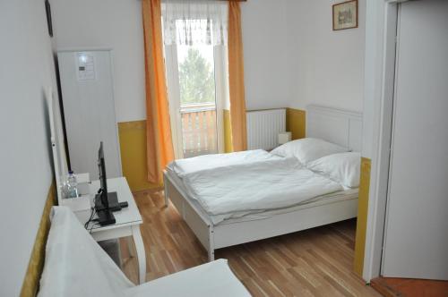 a bedroom with a bed and a window at Gloriett Panzió in Fertőboz