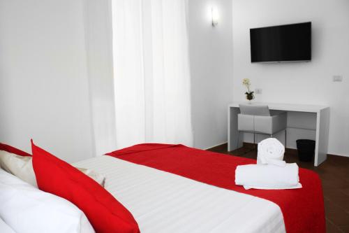 um quarto com uma cama vermelha e branca e uma televisão em Roma Resort Colosseum em Roma