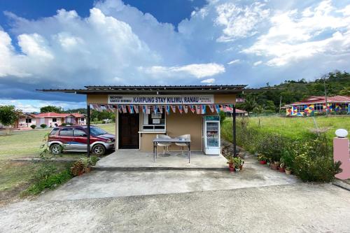 a small building with a table in front of it at Hotel O Kampung Stay Kilimu in Ranau