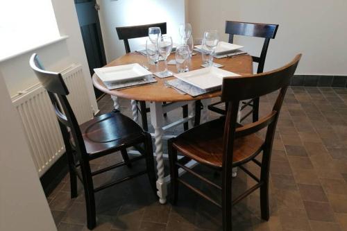 a wooden table with chairs and wine glasses at No 1 Church Street in Whitchurch