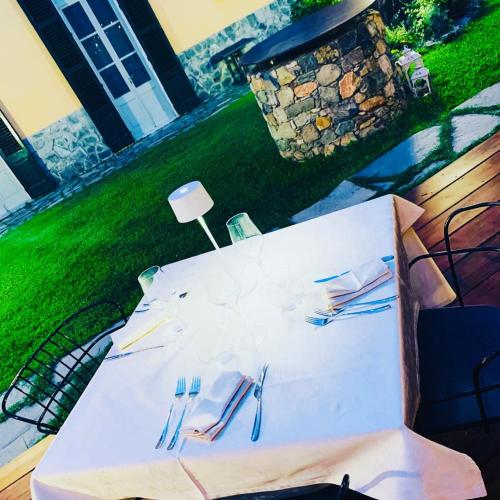 a white table with forks and napkins on it at Relais Real Collegio in Noli