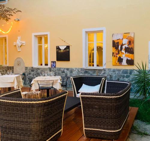 a restaurant with wicker chairs and tables at Relais Real Collegio in Noli