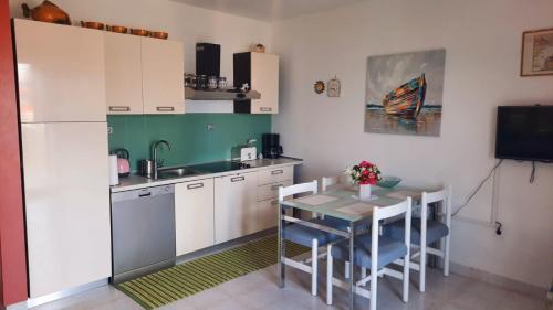 a small kitchen with a table and a refrigerator at Oasis Apartments in Sutivan