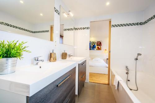 Un baño con dos lavabos, una bañera y una ducha. en Domaine de la Pointe de Kerhostin, en Saint-Pierre-Quiberon