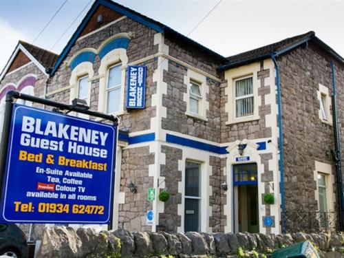 a blue sign in front of a brick house at Blakeney Guest House in Weston-super-Mare