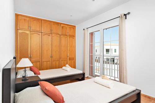 a bedroom with two beds and a large window at Villa Menorca BAY 4 by Mauter Villas in Sa Caleta