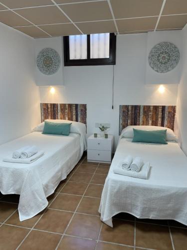 a bedroom with two beds with towels on them at casa espiga in Benalmádena