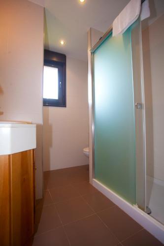 a bathroom with a glass shower with a toilet at Brisas de Caravia in Prado