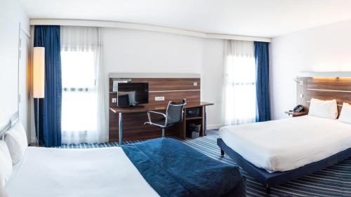 a hotel room with two beds and a desk at Hôtel Marseille Centre Gare Saint-Charles in Marseille
