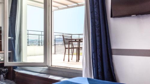 a room with a window with a view of a balcony at Hôtel Marseille Centre Gare Saint-Charles in Marseille
