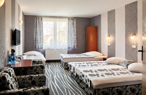 a hotel room with three beds and a window at Hotel Horda in Słubice