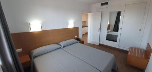 a small bedroom with a bed and a mirror at Primavera Loix in Benidorm