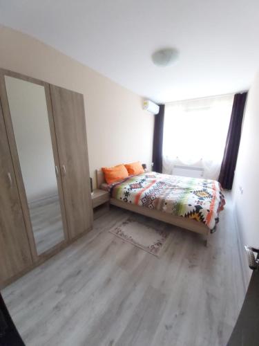 - une chambre avec un lit et une grande fenêtre dans l'établissement Apartment Krasi, à Velingrad