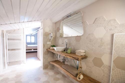 y baño con lavabo y espejo. en B&B Botton d'Oro Valle Imagna en Fuipiano Valle Imagna