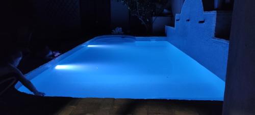 a swimming pool with a blue light in the dark at Casa Las Torres in Medina de las Torres