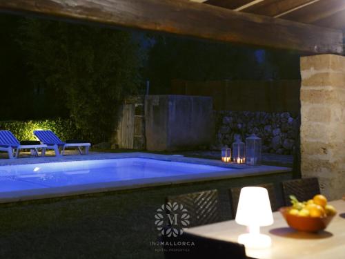 een zwembad in een achtertuin met een tafel en stoelen bij VILLA CAN PERIC WITH POOL Quiet and spacious in Pollença