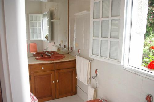 uma casa de banho com um lavatório e um espelho em Vivienda tradicional con jardín y patio interior em Vilanova de Arousa