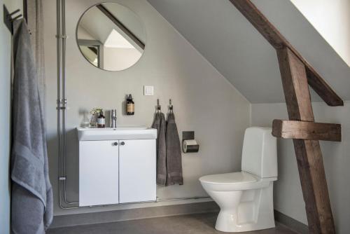 uma casa de banho com um WC e um espelho. em Gumbalde Resort em Stånga