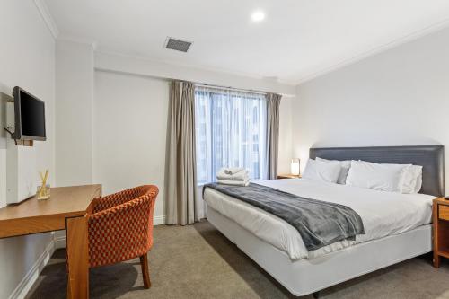 a bedroom with a bed and a desk and a computer at Auckland Apartment City Centre in Auckland