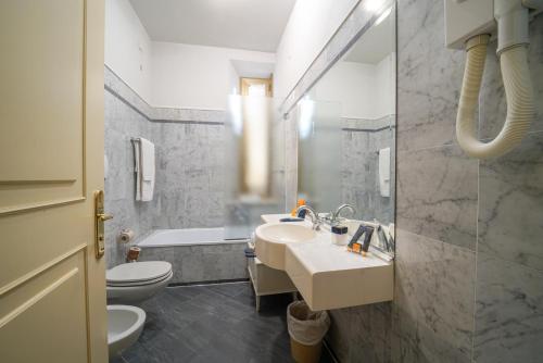 een badkamer met een wastafel, een toilet en een bad bij HG Hotel Cappelli in Montecatini Terme