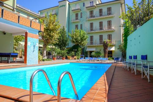 a swimming pool in front of a building at Hotel Cappelli in Montecatini Terme