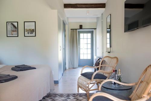 a room with a bed and a chair and a television at Gumbalde Resort in Stånga