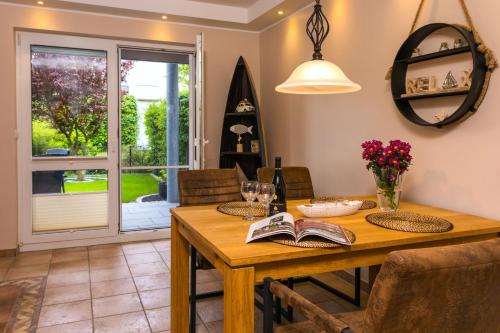 a dining room with a wooden table with a book at Meeresbrise in Ostseebad Karlshagen