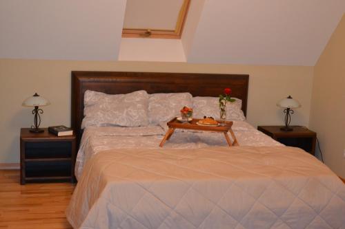 um quarto com uma cama com uma mesa com flores em Vila Vėtrūnė em Šventoji