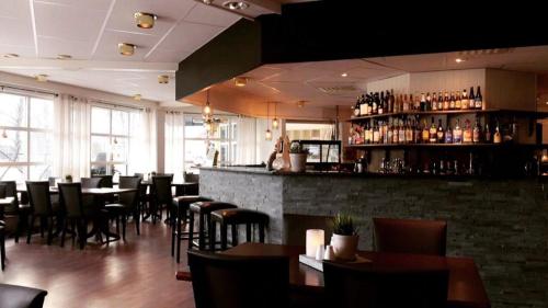 een restaurant met tafels en stoelen en een bar bij Grong Hotell in Grong
