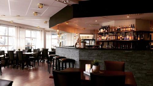 a restaurant with tables and chairs and a bar at Grong Hotell in Grong