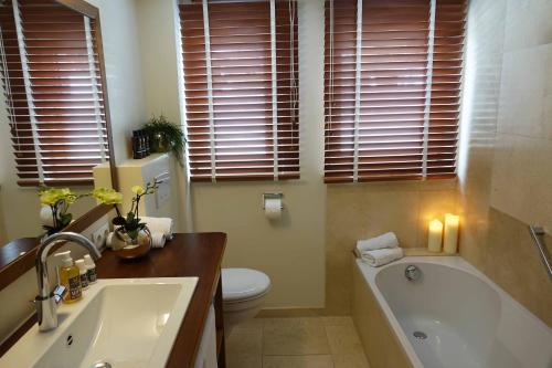 a bathroom with a tub and a toilet and a sink at Schittlerhaus in Oberstdorf