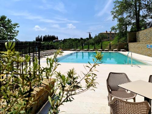 a swimming pool with chairs and a table at Hotel Stara šola - Oleander Resort in Izola