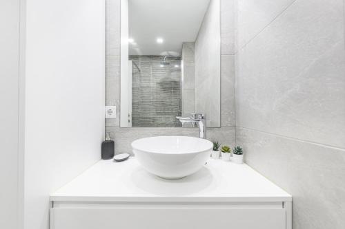 a white bathroom with a sink and a shower at Estúdio R&M - Gerês in Geres