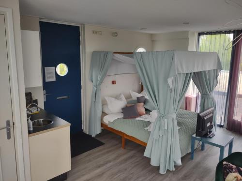 a bedroom with a bed with a canopy at B&B Landgoed Rijckholt in Geersdijk