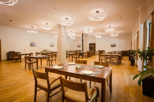 a dining room with wooden tables and chairs at Gistola Hotel Mestia in Mestia