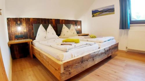 ein großes Holzbett in einem Zimmer in der Unterkunft Schirfhof in Michaelerberg
