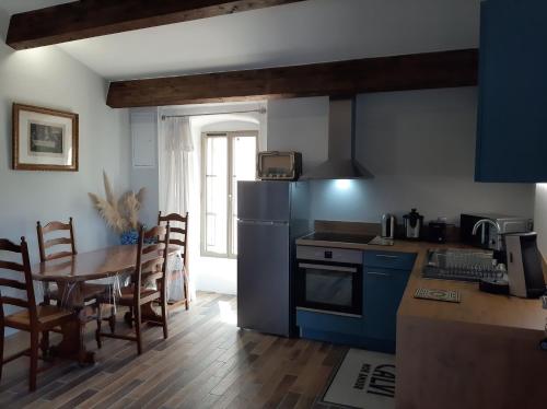 a kitchen with a table and a blue refrigerator at Casa Santa in Calvi