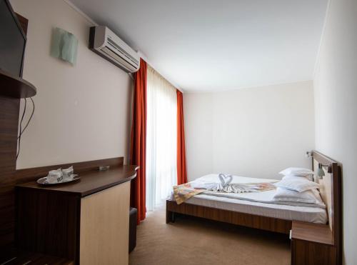 a bedroom with a bed and a desk and a window at Hotel Del Mar Venus in Venus