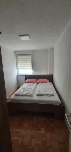 a small bed in a small room with a window at APARTMENT 075 TUZLA in Tuzla