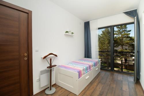 um quarto com uma cama e uma grande janela em Apartman Kaćun - Divčibare em Divčibare