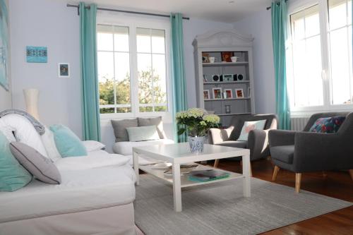uma sala de estar com um sofá branco e uma mesa em La Source em Hermanville-sur-Mer