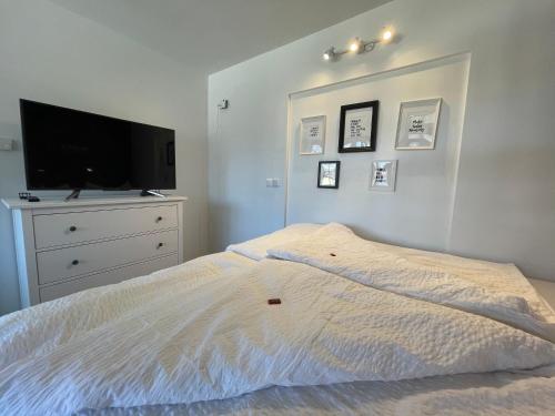 a bedroom with a bed with a tv and a dresser at Entzückende Garconniere im Herzen Spittals in Spittal an der Drau