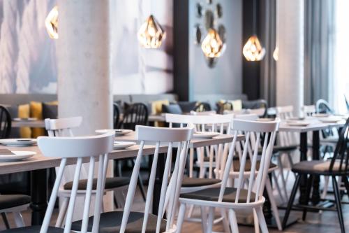 a row of tables and chairs in a restaurant at HARBR Hotel Ludwigsburg, a member of Radisson Individuals in Ludwigsburg